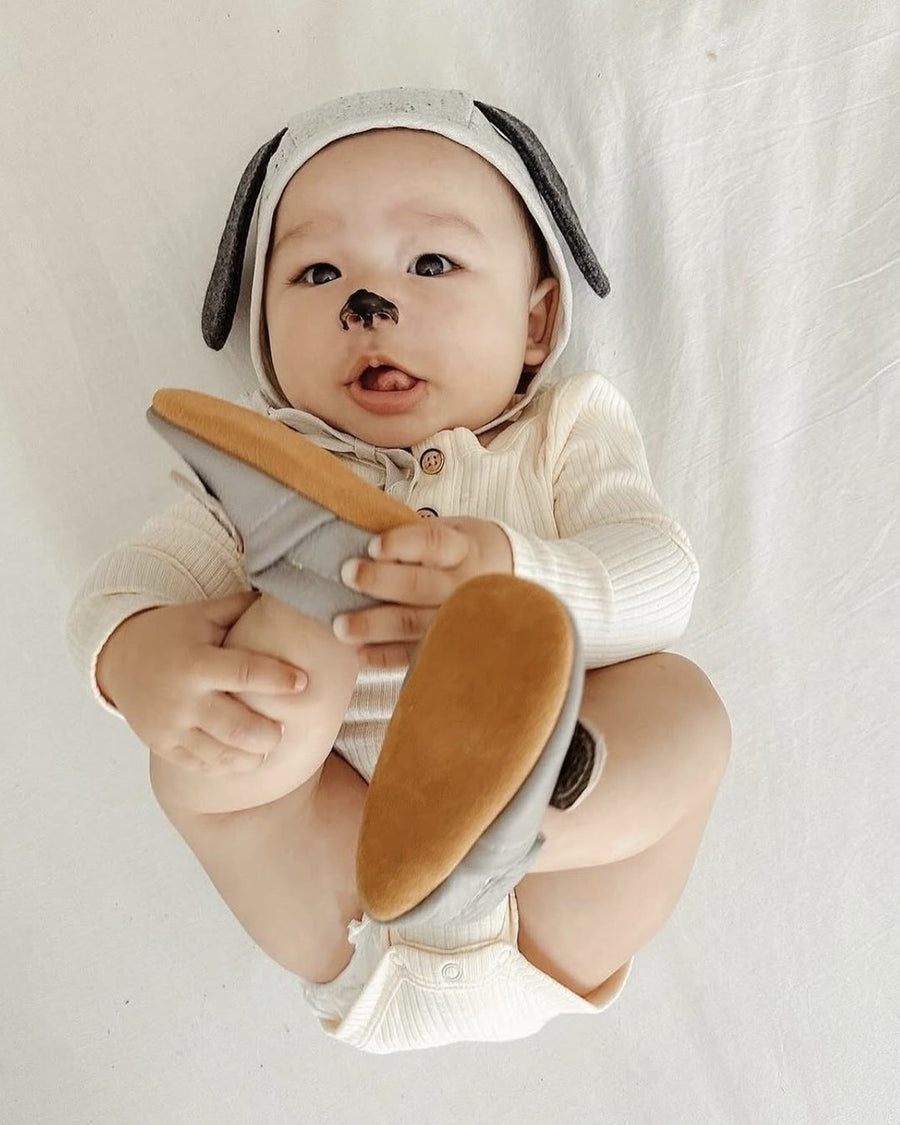 Baby boy holding his soft sole leather moccasins