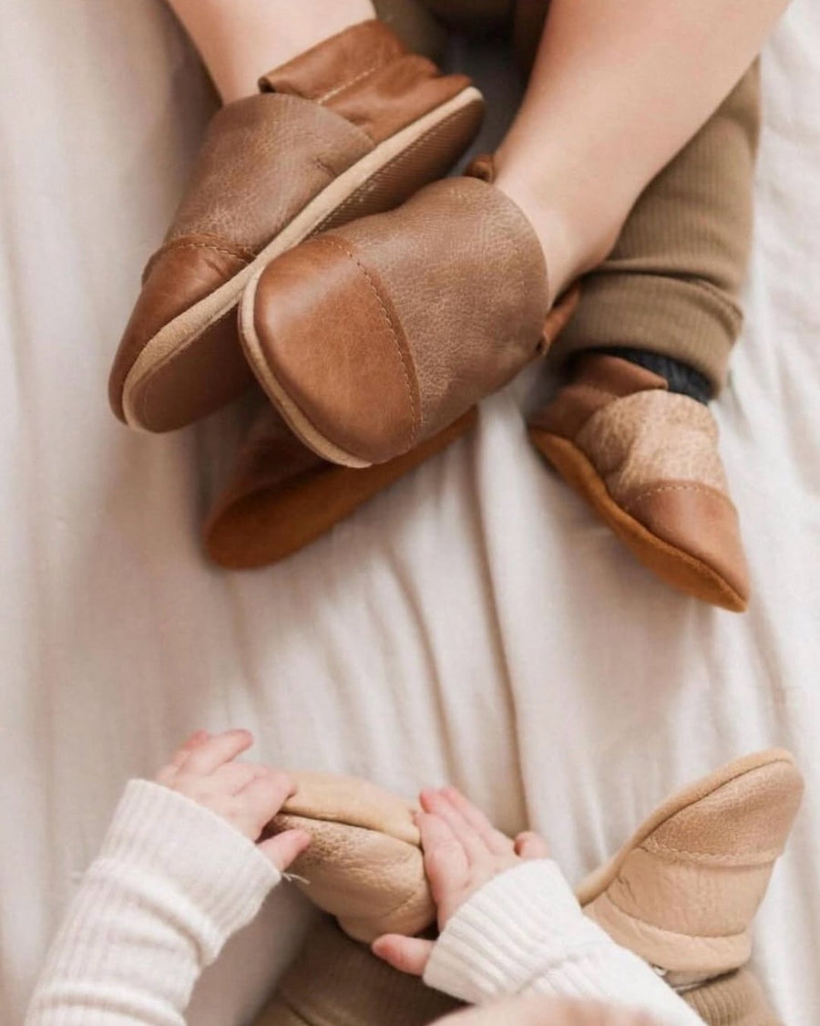 Parent and child wearing matching brown leather moccasins